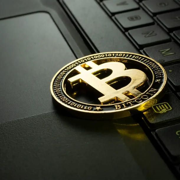 A representation of a golden bitcoin sitting on top of a laptop keyboard