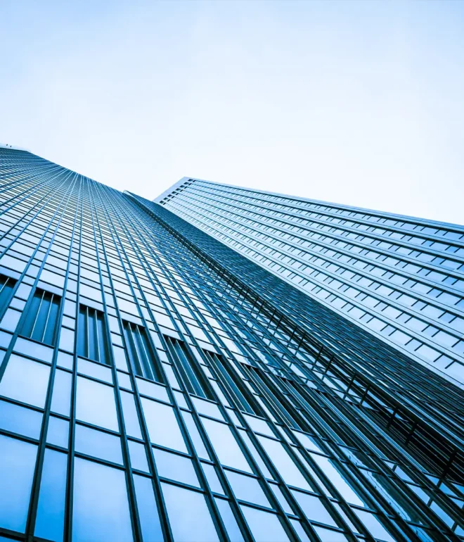Looking up at a glass and metal skyscraper