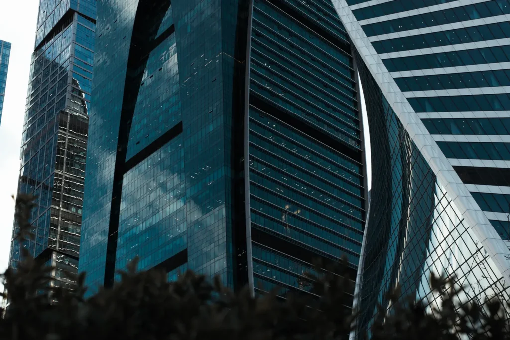 A street level view, looking up at a corporate glass and steel skyscraper