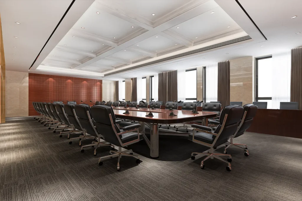An empty board room filled with chairs arranged around a central table.