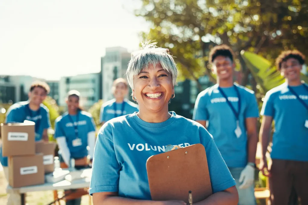 A group of smiling volunteers face the camera