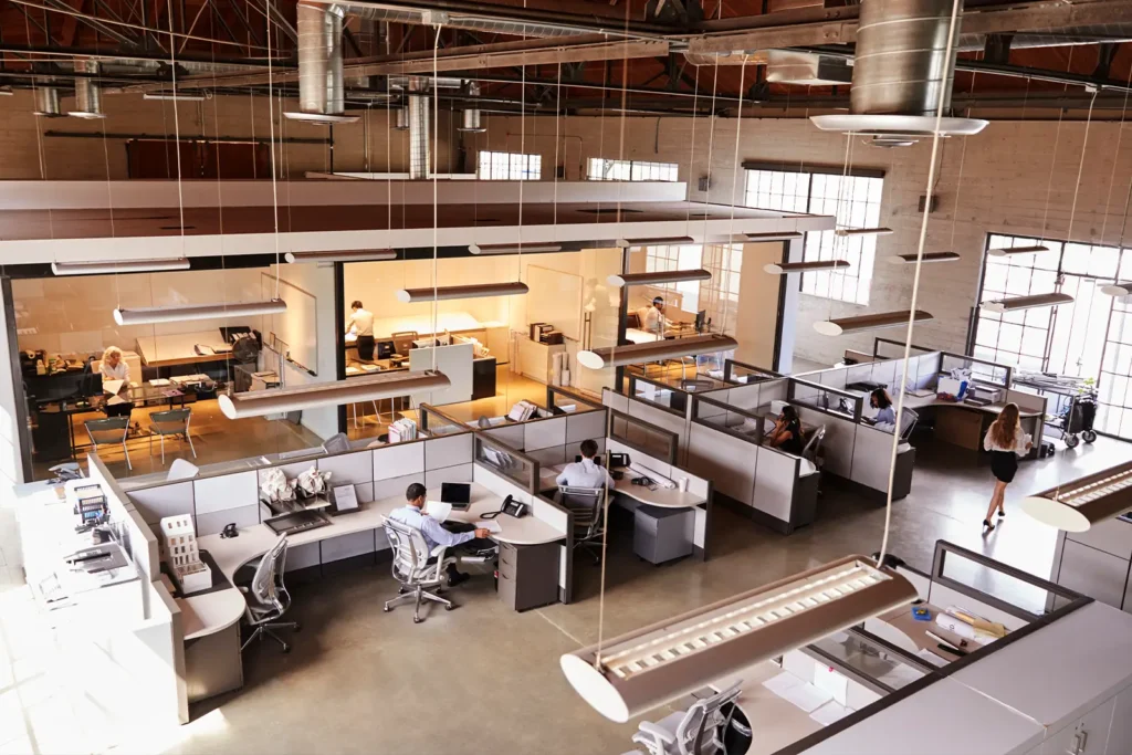 An elevated view of a large open office, with multiple cubicles and workers.