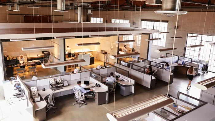 An elevated view of a large open office, with multiple cubicles and workers.