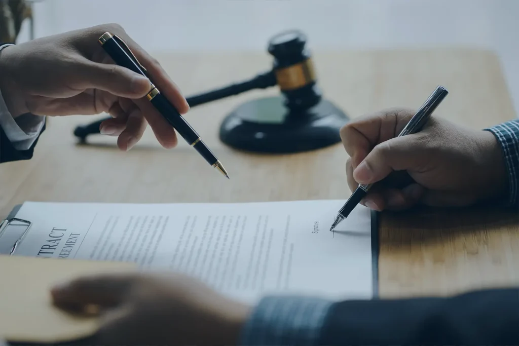 A close-up of a man's hand, signing a legal document