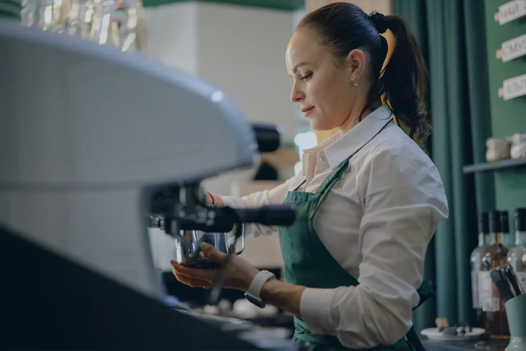 A barista prepares a cup of coffee in a business