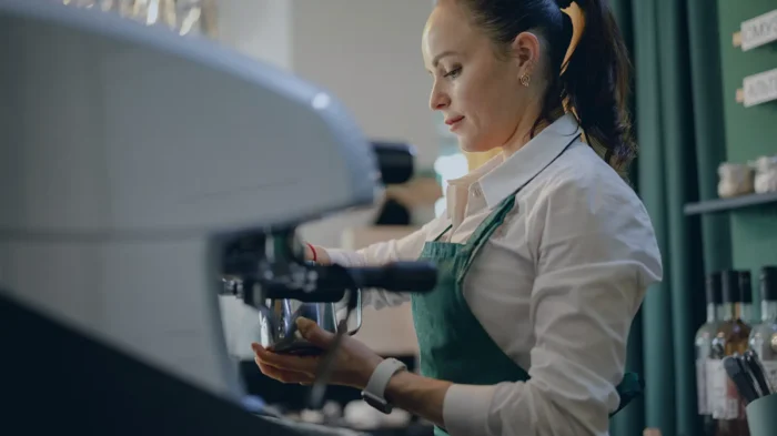 A barista prepares a cup of coffee in a business