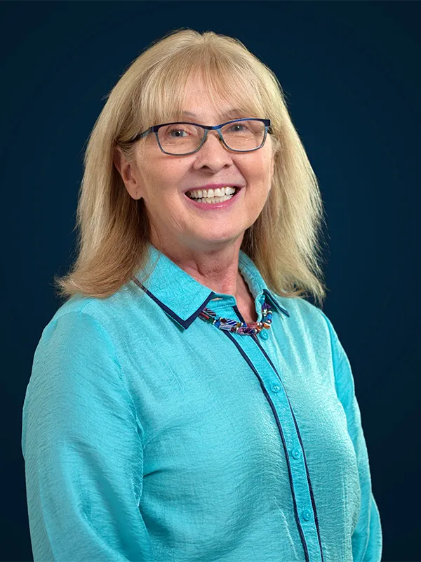 A headshot of attorney Ruth Binger in front of a blue background